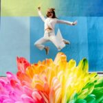 person dressed in white leaping into colours