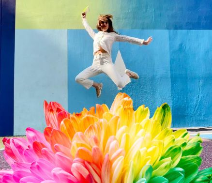 person dressed in white leaping into colours