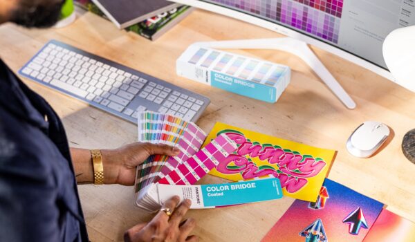Designer working at desk with Pantone Color Bridges