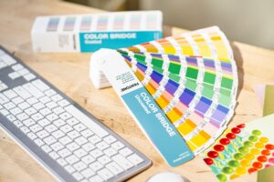 Two Pantone GP6102C Color Bridge fans open next to a keyboard