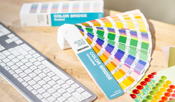 Two Pantone GP6102C Color Bridge fans open next to a keyboard